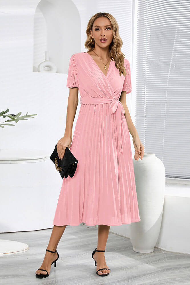 Robe rose plissée avec accessoires robe bohème et pochette noire pour un look raffiné.