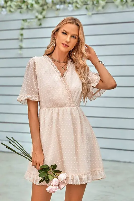 Robe à pois courte beige, coupe portefeuille, idéale pour une allure romantique et chic.