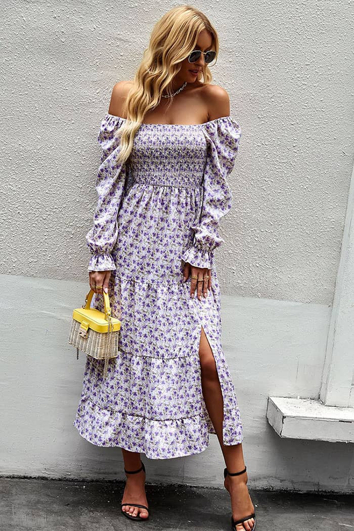 Robe demoiselle d’honneur champêtre à fleurs lilas, coupe longue et fendue avec manches bouffantes et encolure bardot.