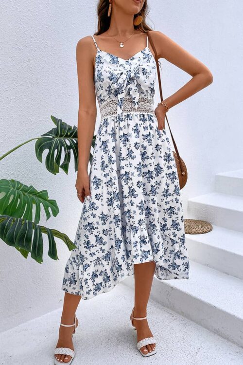 Robe demoiselle d’honneur champêtre mi-longue à fines bretelles et imprimé fleuri bleu, avec taille marquée et détails ajourés.